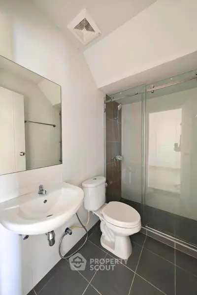Modern bathroom with glass shower and sleek fixtures in a contemporary home.