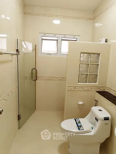 Modern bathroom with glass shower and sleek toilet design.