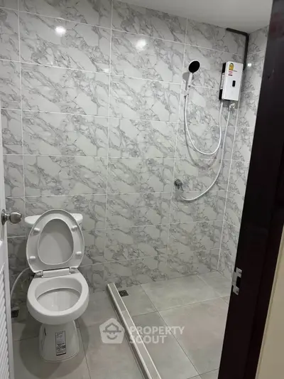 Modern bathroom with marble tiles and shower in a real estate property.