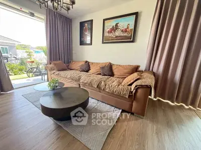Spacious living room with elegant decor and garden view, featuring a cozy sofa and modern coffee table.