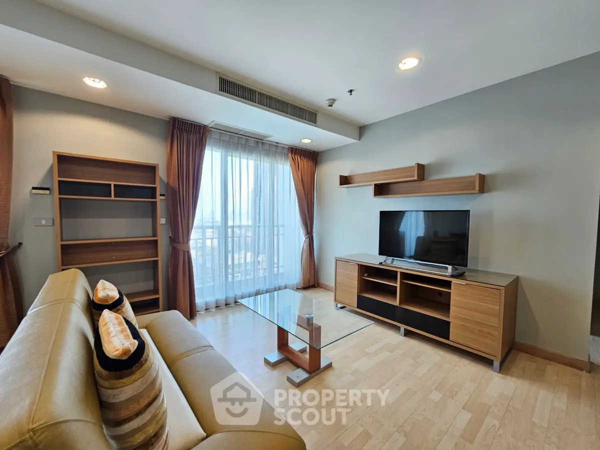 Modern living room with stylish furniture and large window offering natural light.
