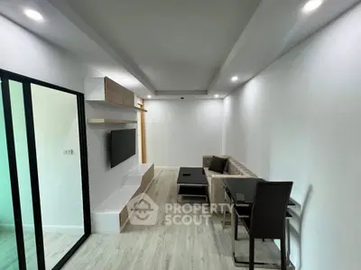 Modern living room with sleek design, featuring a wall-mounted TV and stylish furniture in a bright, minimalist space.