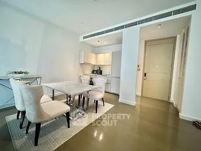 Modern dining area with elegant chairs and sleek kitchen in luxury apartment.