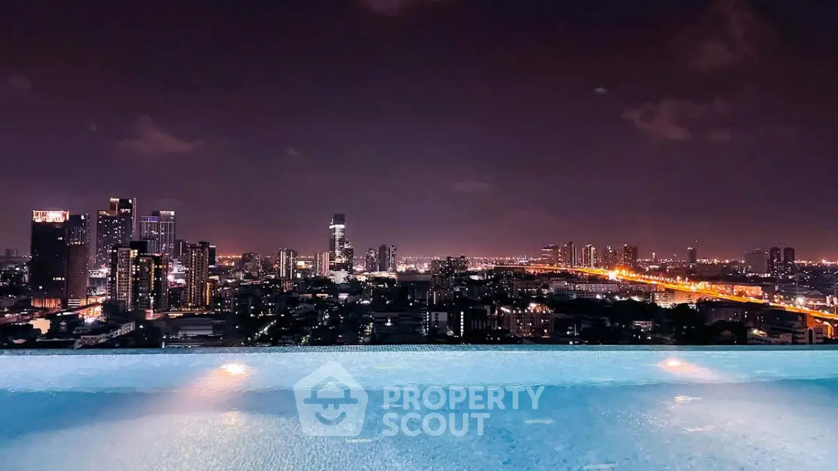 Stunning rooftop pool with breathtaking city skyline view at night