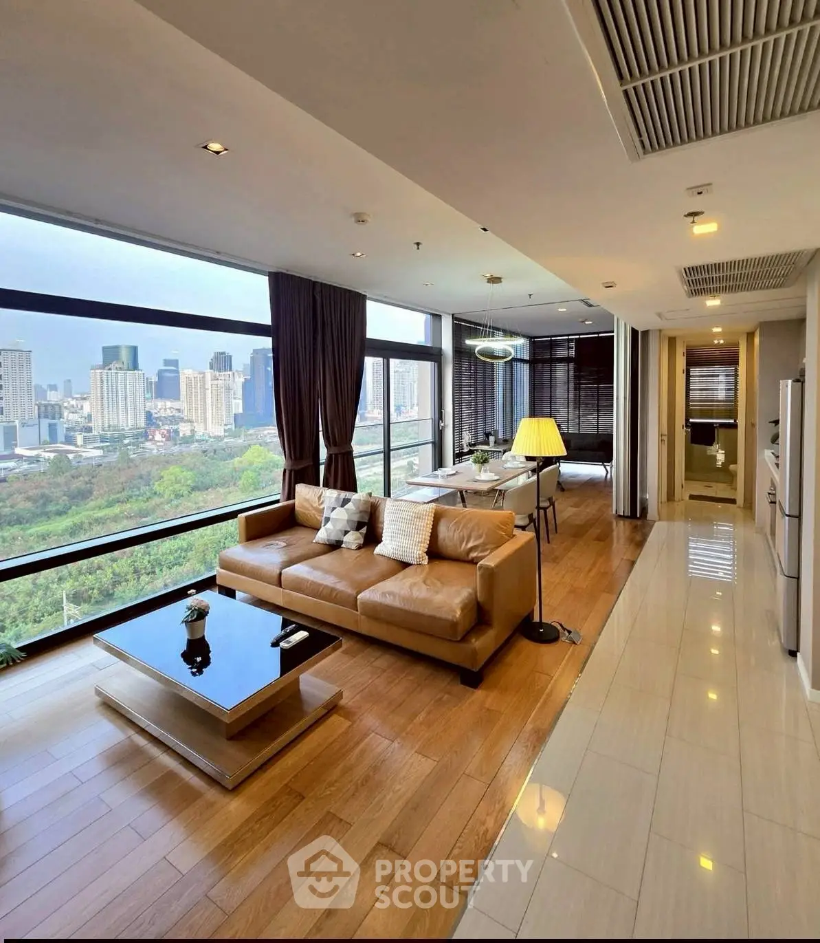 Luxurious corner unit living room with panoramic city views and elegant modern furnishings.