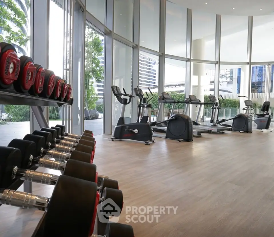 Spacious modern gym with city view and state-of-the-art equipment.