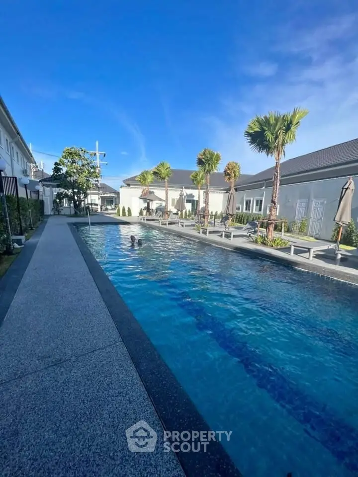 Luxurious outdoor swimming pool with palm trees and modern architecture