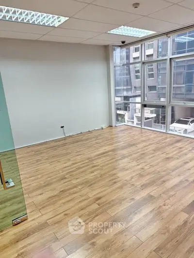 Spacious office space with large windows and wooden flooring