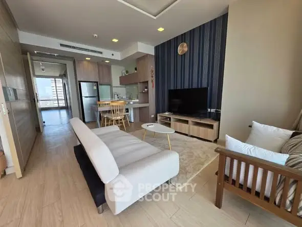 Modern living room with open kitchen and stylish decor in a high-rise apartment.