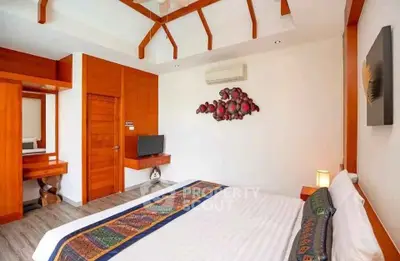 Spacious bedroom with modern decor and wooden accents, featuring a comfortable bed and wall-mounted TV.