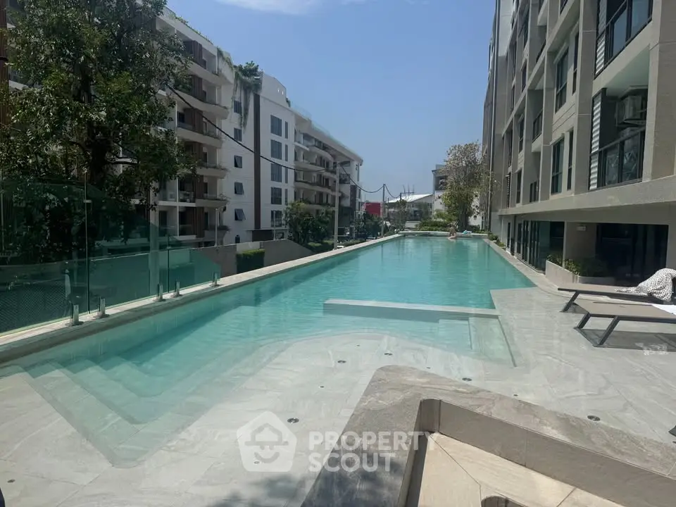 Luxurious apartment complex with stunning outdoor pool and modern architecture.