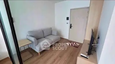 Cozy living room with modern sofa and TV, perfect for relaxation.