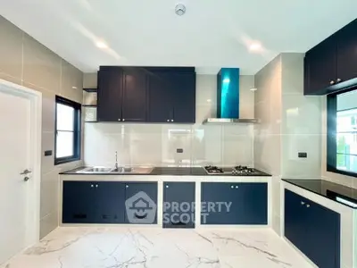 Modern kitchen with sleek black cabinets and marble flooring
