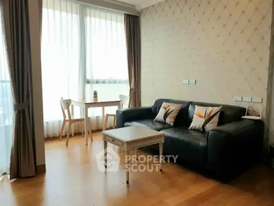 Charming living room with elegant decor and natural light, featuring a cozy sofa and dining area.