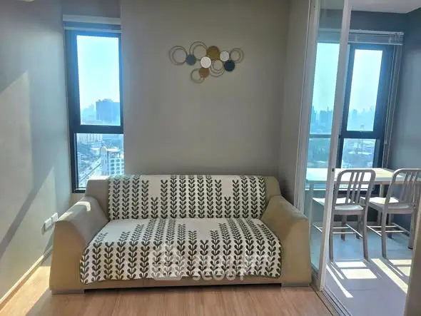 Modern apartment living room with cozy sofa and city view.