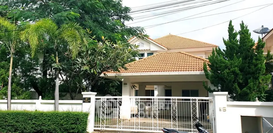 Charming suburban house with tiled roof and lush greenery, perfect for family living.