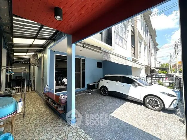 Modern townhouse with carport and tiled patio in sunny urban setting.
