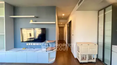 Modern living room with sleek TV setup and stylish shelving in a contemporary apartment.