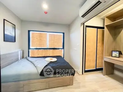 Modern bedroom with cozy bed, built-in wardrobe, and air conditioning in a stylish apartment.