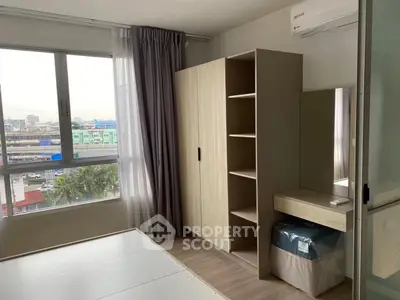 Modern bedroom with large window and built-in wardrobe offering city views.