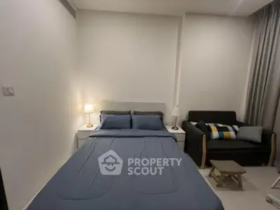 Cozy bedroom with modern decor, featuring a comfortable bed and stylish sofa, perfect for relaxation.