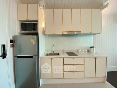 Modern kitchen with sleek cabinetry and stainless steel appliances in a stylish apartment