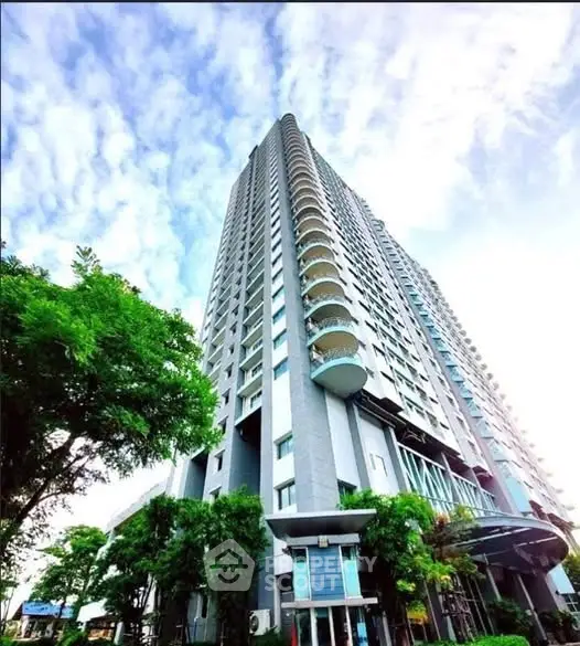 Stunning high-rise building with modern architecture and lush greenery, perfect for urban living.