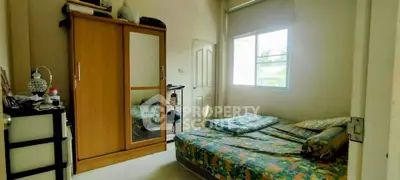 Cozy bedroom with natural light and wooden wardrobe