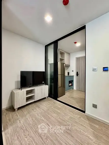 Modern apartment interior with sleek kitchen and cozy living area, featuring stylish flooring and contemporary design.