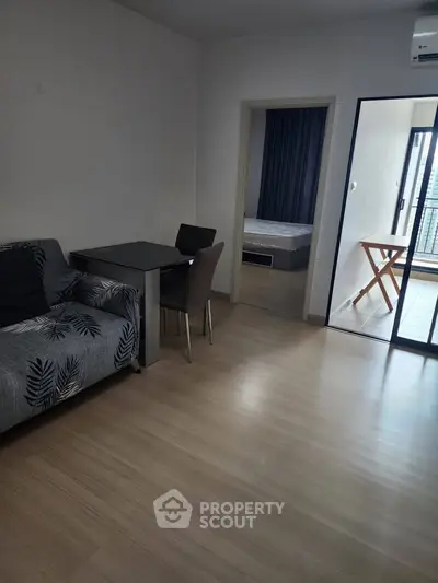 Modern apartment interior with cozy living room and bedroom view, featuring stylish furniture and balcony access.