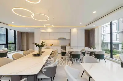 Luxurious modern dining area with elegant lighting and spacious seating in a stylish apartment.