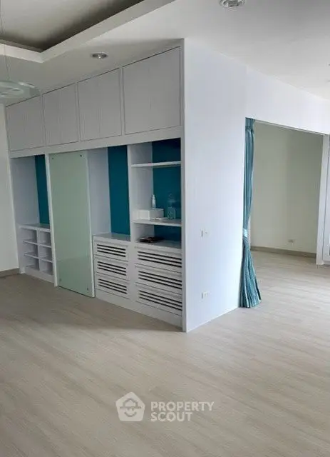 Spacious modern living area with built-in storage and light wood flooring.
