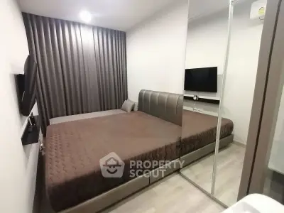 Modern bedroom with sleek design and mirrored wardrobe in a contemporary apartment.