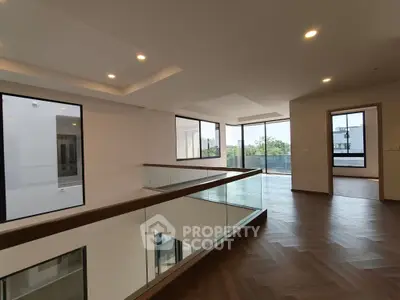 Spacious modern living room with large windows and elegant wooden flooring