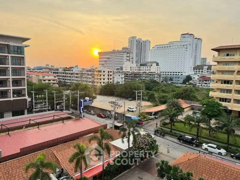 Stunning cityscape view with sunset over urban skyline and lush greenery.