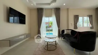 Spacious modern living room with elegant decor and pool view, featuring stylish furniture and natural light.