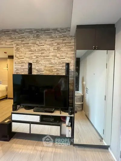 Modern living room with stylish stone accent wall and sleek TV setup