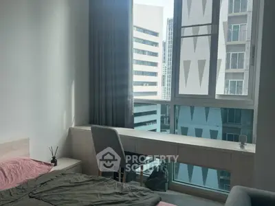 Modern bedroom with city view, featuring sleek furniture and large windows for natural light.