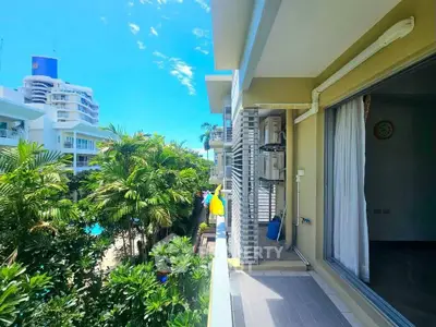 Spacious balcony with lush garden view in modern apartment complex