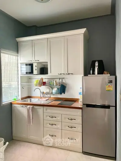 Modern kitchen with sleek cabinetry and stainless steel appliances in a compact layout.