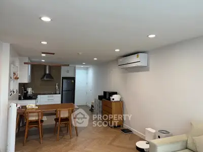 Modern open-layout kitchen and living area with sleek appliances and stylish decor.