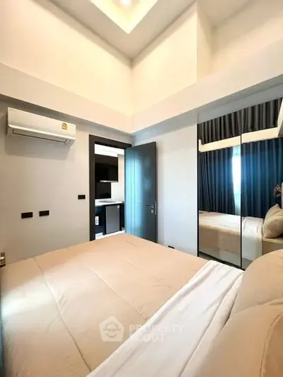 Modern bedroom with mirrored closet and sleek air conditioning unit