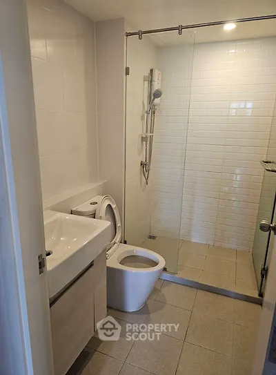 Modern bathroom with glass shower and sleek fixtures in a contemporary apartment.