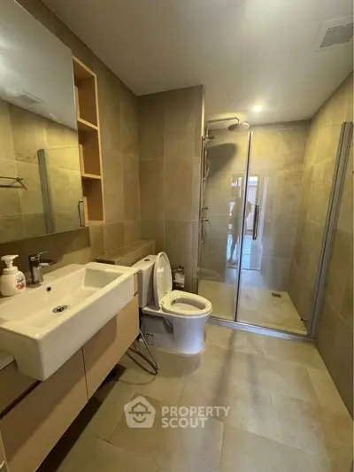Modern bathroom with sleek design, featuring a spacious shower and elegant fixtures.