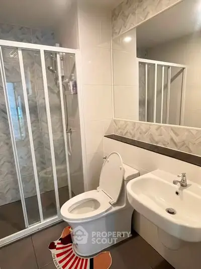 Modern bathroom with shower and sleek fixtures in a contemporary apartment.