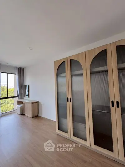 Spacious bedroom with large wardrobe and scenic window view