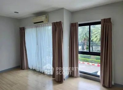 Spacious room with large windows and air conditioning, perfect for natural light and comfort.
