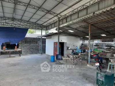 Spacious industrial-style outdoor workspace with metal roofing and concrete flooring.