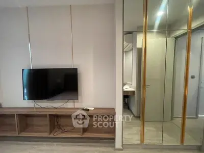 Modern living room with wall-mounted TV and mirrored closet doors
