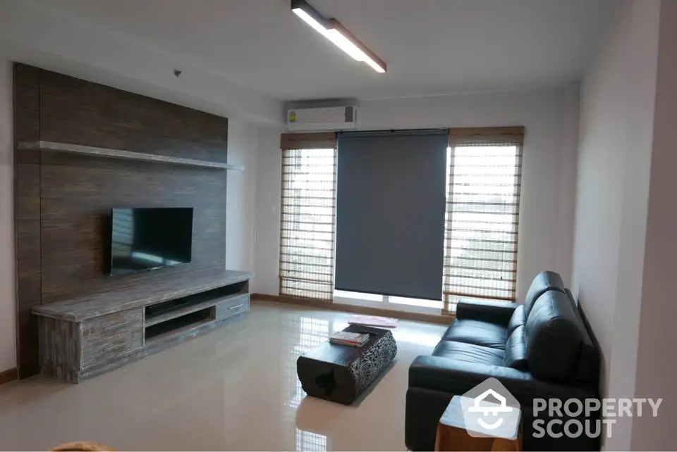 Modern living room with sleek furniture and large windows offering natural light.